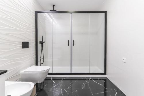 a bathroom with a toilet and a glass shower at Outstanding Santos Spacious 2 Bedroom Apt w AC in Lisbon