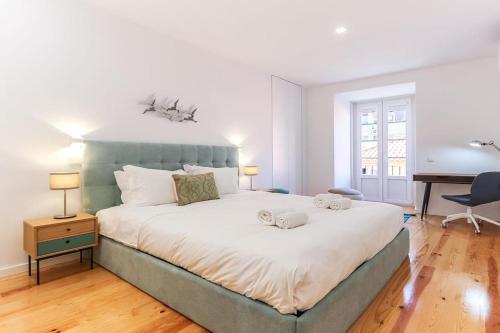 a bedroom with a large bed and a desk at Outstanding Santos Spacious 2 Bedroom Apt w AC in Lisbon