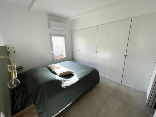 - une chambre avec un lit et des armoires blanches dans l'établissement Charmante maison avec piscine, à Garons
