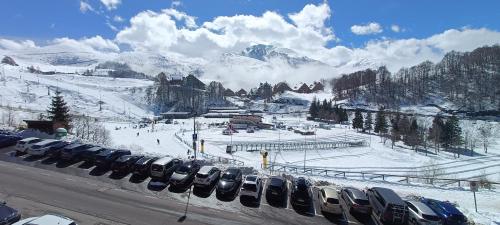 a bunch of cars parked on the side of a snow covered mountain at [Prato Nevoso] Appartamento fronte conca in Prato Nevoso
