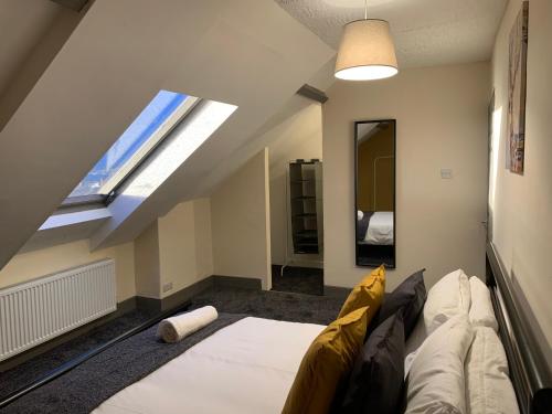 a attic room with a bed and a window at Rectory4 -Lovely 4 Bdrm 6 Beds Gateshead Free Parking in Gateshead