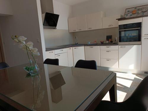 eine Küche mit einem Tisch und einer Blumenvase darauf in der Unterkunft Apartman Slatina in Tuzla