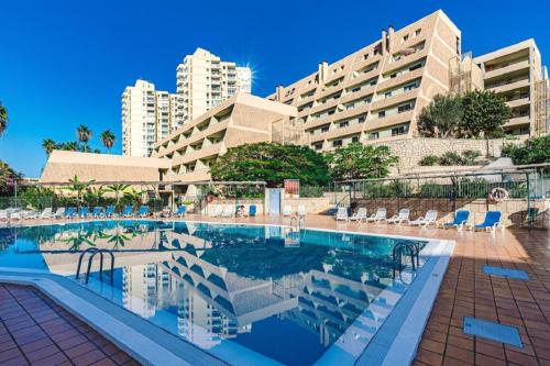 a swimming pool in front of a large building at Royal View Apartment - Playa de Las Americas in Playa de las Americas