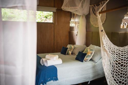 a bed in a room with a hammock at Bonito Paraiso Ilha Grande in Abraão