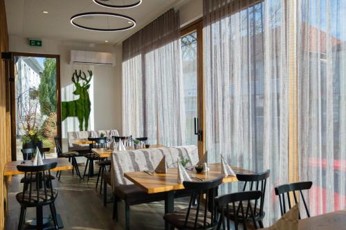 a restaurant with tables and chairs and a large window at Berghamer's Gasthof Hotel in Neukirchen am Walde