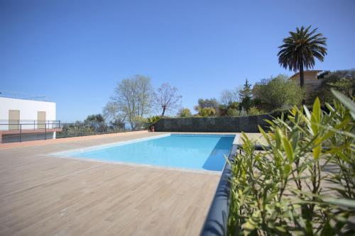 - une piscine dans une cour avec une terrasse en bois dans l'établissement DOMAINE DES ROSES 3 AP4400 By Riviera Holiday Home, à Nice