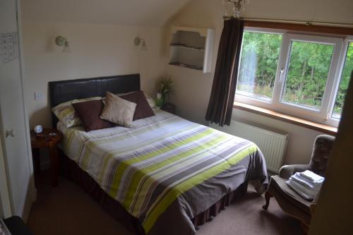 1 dormitorio con cama y ventana en The Lilacs, en Ashbourne