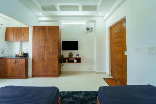 um quarto com duas camas e uma televisão e uma porta em Wandr Taurus em Bangalore