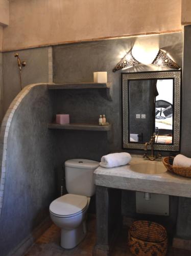 a bathroom with a toilet and a sink and a mirror at Riad Palmier in Marrakech
