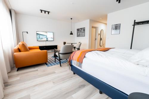 een slaapkamer met een bed, een bureau en een stoel bij Hlemmur Suites in Reykjavík