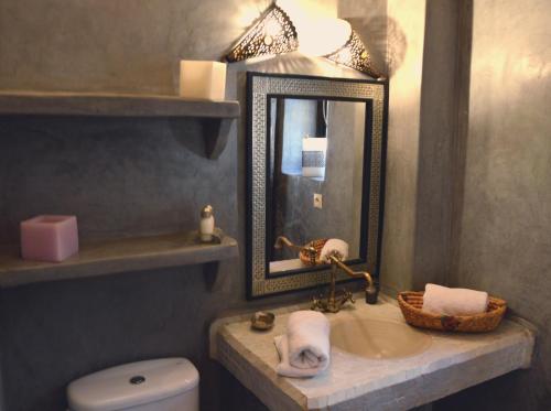 a bathroom with a sink and a mirror and a toilet at Riad Palmier in Marrakech