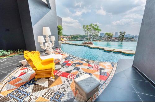 吉隆坡的住宿－Arte Cheras Kuala Lumpur by Loop Suites，游泳池设有黄色椅子和色彩缤纷的地毯