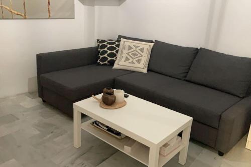 sala de estar con sofá y mesa de centro en Estudio en el corazón deTriana., en Sevilla