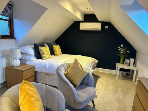 a attic bedroom with a bed and a chair at Stunning studio flat with own large garden in Shrewsbury SLEEPS 2 in Shrewsbury