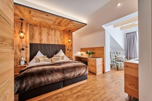 a bedroom with a large bed and wooden walls at Landhotel Schneider in Riedenburg