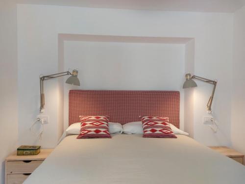 a bedroom with a large bed with two red pillows at La Niña de Vejer in Vejer de la Frontera