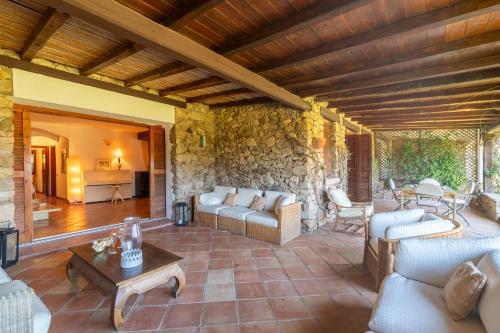 uma sala de estar com sofás e uma parede de pedra em L’aldiola - Happy Rentals em Porto Rotondo
