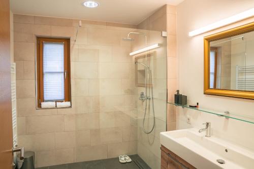 a bathroom with a shower and a sink at Steinberghaus Apartments in Leogang