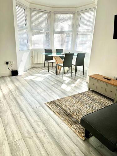 a dining room with a table and chairs and a rug at Luton flat with parking in Luton