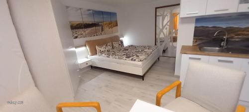 Dormitorio pequeño con cama y lavamanos en Appartement auf Rügen, en Sagard