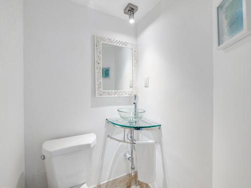 a bathroom with a toilet and a glass sink at Bright and Sunny 2BR !!Close to Peanut Island!! in Riviera Beach