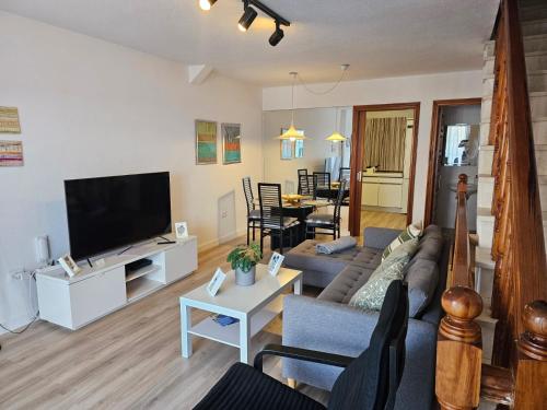 un soggiorno con un divano e una TV di Sunny Holidays in Casa Familiar Playa La Arena a Puerto de Santiago