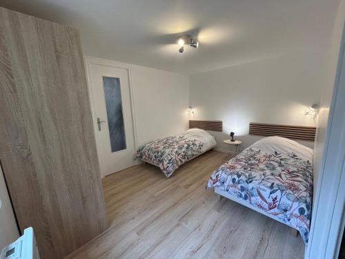 une chambre avec deux lits dans une pièce dans l'établissement Gîte Mer et Campagne, à Saint-Martin-Plage