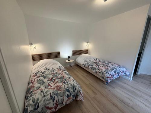 une chambre avec deux lits dans une pièce dans l'établissement Gîte Mer et Campagne, à Saint-Martin-Plage