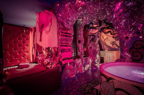 the Sin Suite في هارلم: غرفة وردية مع سرير وحوض استحمام