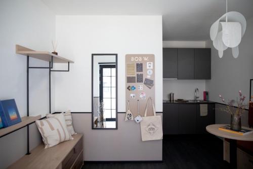 a kitchen with white walls and a table with a mirror at Bob W Østerbro Copenhagen in Copenhagen