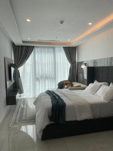 a bedroom with a large bed and a large window at Kass Towers, Studio Apartment in Accra