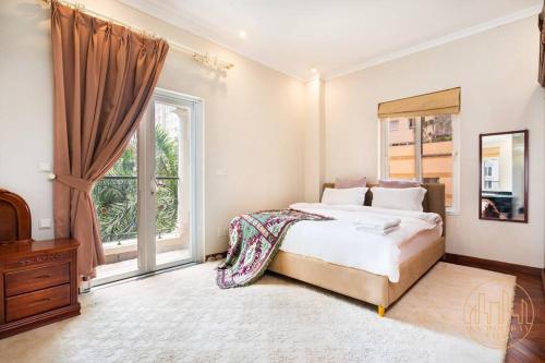 - une chambre avec un lit et une grande fenêtre dans l'établissement KN1 HOLIDAY VILLA, à Hô-Chi-Minh-Ville