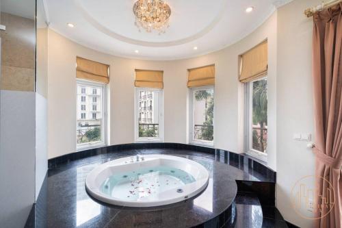 - une grande salle de bains avec une grande baignoire dans une chambre dotée de fenêtres dans l'établissement KN1 HOLIDAY VILLA, à Hô-Chi-Minh-Ville