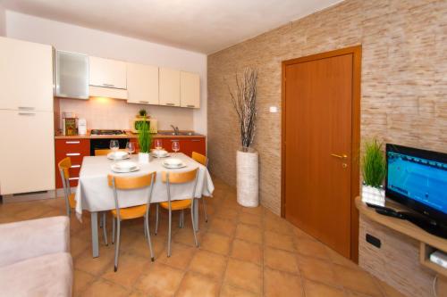 a kitchen and dining room with a table and chairs at Residence Delle Rose in Tremosine Sul Garda