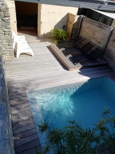 - une piscine dans un jardin avec une terrasse en bois dans l'établissement Gites Le bois des Tréans, à Les Moutiers
