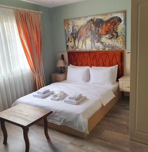 a bedroom with a bed with a horse painting on the wall at st945 Palas Otel in İzmir