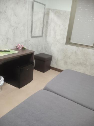 a bedroom with a desk and a bed and a sink at Nuñez Tomelloso in Tomelloso