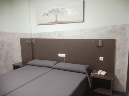 a bedroom with a bed and a picture of a tree at Nuñez Tomelloso in Tomelloso