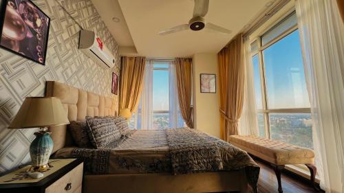 a bedroom with a bed and a large window at High Rise Executive Apartments Facing Centaurus Mall Islamabad in Islamabad