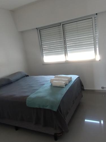 - une chambre avec 2 serviettes sur un lit et 2 fenêtres dans l'établissement DEPARTAMENTO - Excelente ubicación y Comodidad 3B, à San Nicolás de los Arroyos