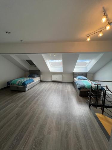 a attic room with two beds and a staircase at City Unterkunft 5 in Heilbronn
