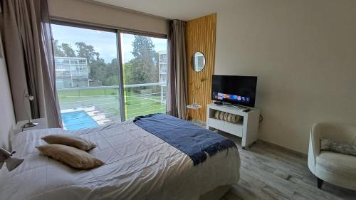 een slaapkamer met een bed en een groot raam bij FerPilar Suite, Concord Pilar in Pilar