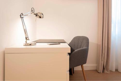 a white desk with a lamp and a chair at Woohoo Rooms Boutique Luna in Madrid