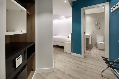 a room with a bathroom with a bed and a toilet at Hotel Parma in San Sebastián