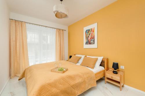 a bedroom with a large bed and a window at Międzywodzie Beautiful Apartment with Garden & Parking by Renters in Międzywodzie
