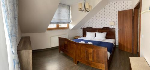 a bedroom with a bed with a blue comforter and a window at Faro Resort in Mrzeżyno