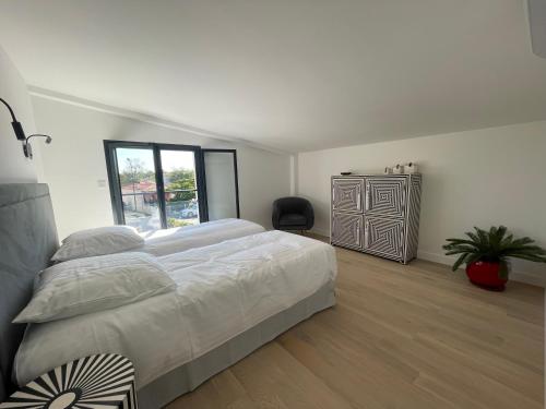 - une chambre avec un lit, une fenêtre et une commode dans l'établissement Charmant duplex avec parking, à Gujan-Mestras