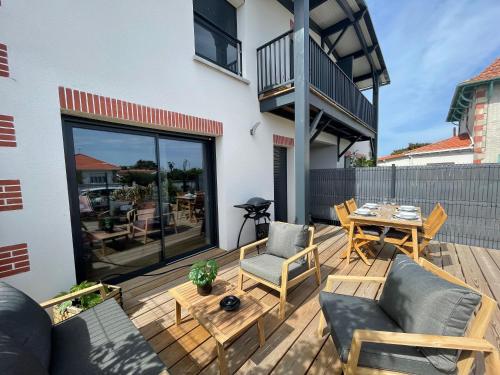 un patio avec une table et des chaises sur une terrasse dans l'établissement Charmant duplex avec parking, à Gujan-Mestras