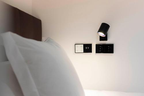 a bedroom with a bed and a light on a wall at Woohoo Rooms Boutique Luna in Madrid