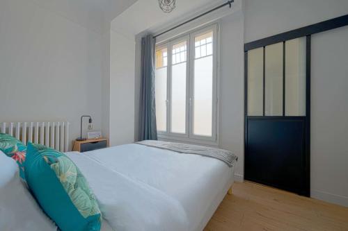 a bedroom with a bed and a large window at Charmant 2 pièces à Issy- les -Moulineaux in Issy-les-Moulineaux